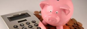 Piggy bank with calculator and some coins