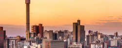 Johannesburg skyline at sunset, representing South Africans working abroad who remain tied to South African tax residency and worldwide income rules